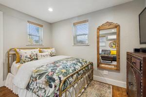 a bedroom with a bed and a mirror at The Cultural District Cottage in Fort Worth