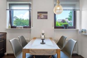 une salle à manger avec une table, des chaises et des fenêtres dans l'établissement Ferienhaus Obergfell, 110 Qm, à Schönwald