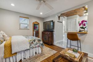 a bedroom with a bed and a television and a chair at The Cultural District Cottage in Fort Worth