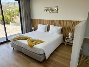 a bedroom with a large bed with a large window at Oásis Suites - Funchal in Funchal