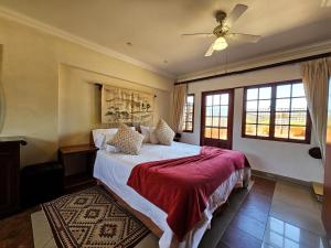 Villa Sant Andrea Boutique Luxury Villa في جوهانسبرغ: غرفة نوم بها سرير ومروحة سقف +69 صورة