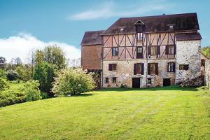 an old house with a large grass field in front of it at Le moulin de la côte chambre d'hôtes in Saint-Vigor