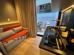 a kitchen with a couch and a stove in a room at Setai à beira-mar com rooftop incrível in João Pessoa