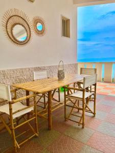 a wooden table and chairs in a room with two mirrors at Villa Monte Sacro - Manfredi Homes& Villas in Mattinata