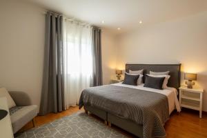 a bedroom with a bed and a couch and a window at Villa Perogil - Charming Oasis in Tavira in Tavira