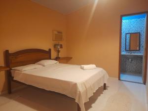 ein Schlafzimmer mit einem Bett mit zwei Handtüchern darauf in der Unterkunft Hospedagem Majestade in Paraty