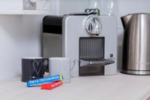 a kitchen counter with coffee mugs and a microwave at Silver Moon Bed & Breakfast in Voorschoten