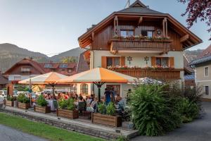 a group of people sitting outside of a building at Pension Oberjörg in Rattendorf