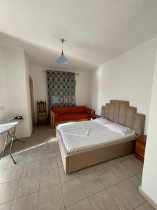 ein Schlafzimmer mit einem Bett, einer Couch und einem Tisch in der Unterkunft Lilis Apartments Sea view in Sarandë