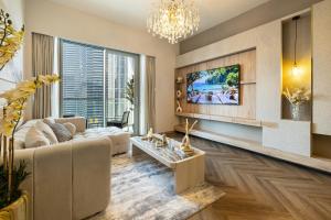 een woonkamer met een bank en een tv bij New Exclusive 2BR Downtown Dubai Burj Khalifa View and Dubai Mall in Dubai