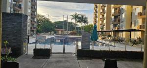 a view of a pool with an umbrella and a building at Hacienda Peñalisa Mango in Ricaurte