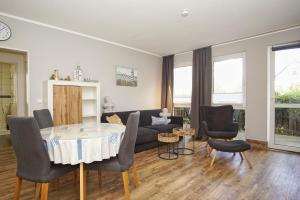 ein Wohnzimmer mit einer Couch und einem Tisch und Stühlen in der Unterkunft strandnahe Ferienwohnung mit eigener Terrasse - Strandhaus Mönchgut FeWo 02 in Lobbe