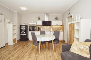eine Küche und ein Wohnzimmer mit Tisch und Stühlen in der Unterkunft strandnahe Ferienwohnung mit eigener Terrasse - Strandhaus Mönchgut FeWo 02 in Lobbe + 16 Fotos