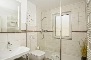 ein weißes Badezimmer mit Toilette und Waschbecken in der Unterkunft strandnahe Ferienwohnung mit eigener Terrasse - Strandhaus Mönchgut FeWo 02 in Lobbe
