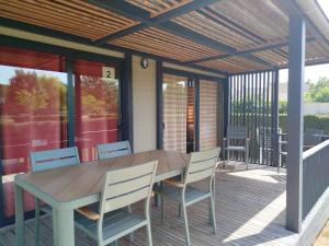 a patio with a wooden table and chairs on a deck at Chalet Portland in Évron