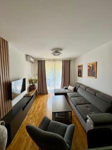 a living room with a couch and a flat screen tv at Infinity Apartment Blue Horizont Przno in Kravlja +5 photos