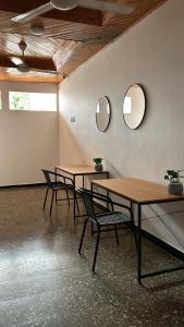 zwei Tische und Stühle in einem Raum mit zwei Spiegeln in der Unterkunft Hotel La Villa de Planeta Rica in Planeta Rica