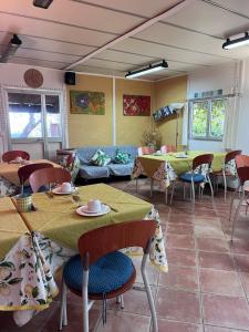 a room with tables and chairs and a couch at Giardino Di Sicilia in SantʼAgata di Militello