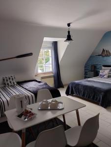 a bedroom with two beds and a table and chairs at Le Manoir de la Pichardière in Cherrueix
