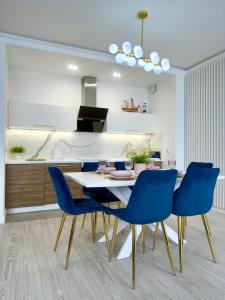 een eetkamer met een tafel en blauwe stoelen bij Apartament Portowy in Giżycko