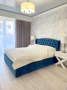 een slaapkamer met een blauw bed met een blauw hoofdeinde bij Apartament Portowy in Giżycko