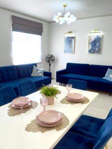 een woonkamer met blauwe banken en een tafel bij Apartament Portowy in Giżycko