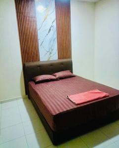 a bed with two red pillows on it in a room at Homestay harmonis kuantan in Kuantan