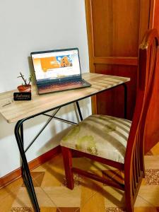a laptop computer sitting on a desk with a chair at Real Marquez in Trujillo