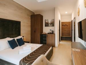 a bedroom with a large bed and a television at RESIDENCE Apartments in Ulcinj