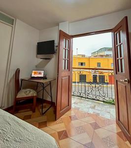 a bedroom with a bed and a desk and a window at Real Marquez in Trujillo