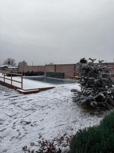 een met sneeuw bedekte straat met een boom en een hek bij Cabañas Golden in San Rafael