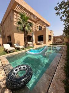 a swimming pool with a tire in the water at Villa familiale a 10km du boulevard Mohamed VI in Marrakesh