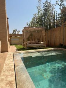 a gazebo sitting next to a swimming pool at Villa familiale a 10km du boulevard Mohamed VI in Marrakesh +3 photos