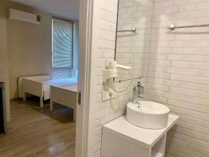 a white bathroom with a sink and a mirror at Boutique Hotel Meidan View in Tbilisi City +34 photos
