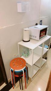 un tavolo bianco con uno sgabello e un microonde di The Cultural Crashpad - 康乃馨旅館 a Hong Kong
