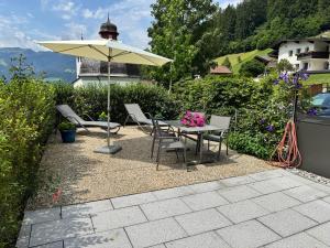 a table and chairs and an umbrella on a patio at MittenDrin in Wildschönau