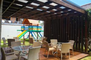 イポジュカにあるAconchegante 2 dormitórios com 3 piscinasのパティオ(テーブル、椅子、プレイグラウンド付)