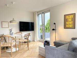 a living room with a table and a dining room at FRITZ21 Ferienwohnung Kellenhusen in Kellenhusen