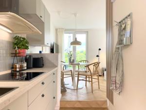 a kitchen with white cabinets and a table with chairs at FRITZ21 Ferienwohnung Kellenhusen in Kellenhusen