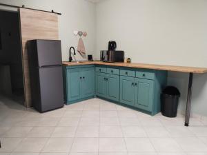 a kitchen with blue cabinets and a counter and a refrigerator at Duikertjie in Groblersdal +2 photos
