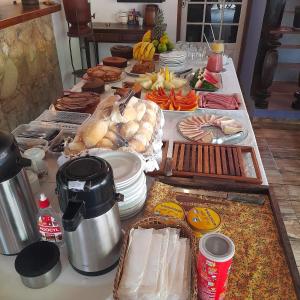 ein Tisch mit vielen verschiedenen Arten von Essen darauf in der Unterkunft Hospedagem Majestade in Paraty