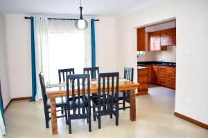 a kitchen and dining room with a wooden table and chairs at Luxury Peace House in Arusha