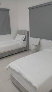 a white room with a bed and a couch at See U Impiana Bentong Homestay in Bentong