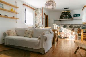 salon z kanapą i kamiennym kominkiem w obiekcie L' Espiga - Casa Rural w mieście Deltebre +44 zdjęcia