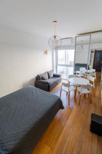 a bedroom with a bed and a couch and a table at Check and Home - Colon IV - 4 Huéspedes Remodelado Zona Güemes in Mar del Plata