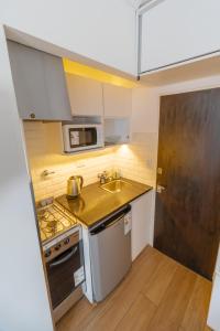 a small kitchen with a sink and a stove at Check and Home - Colon IV - 4 Huéspedes Remodelado Zona Güemes in Mar del Plata