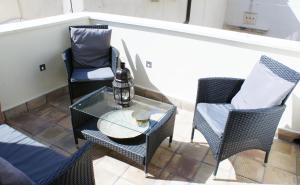 a patio with two chairs and a glass table at Alma Ortigiapart in Siracusa