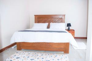 a bedroom with a bed with a wooden headboard at Luxury Peace House in Arusha