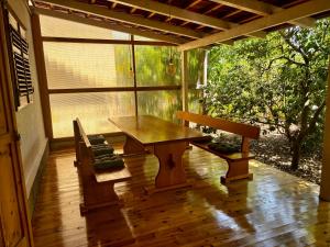 a porch with a wooden table and a bench at Mandarin Garden House in Orebić