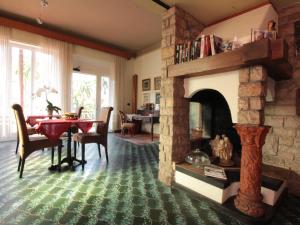 a living room with a fireplace with a table and a dining room at B&B Villa Mirella in Bordighera